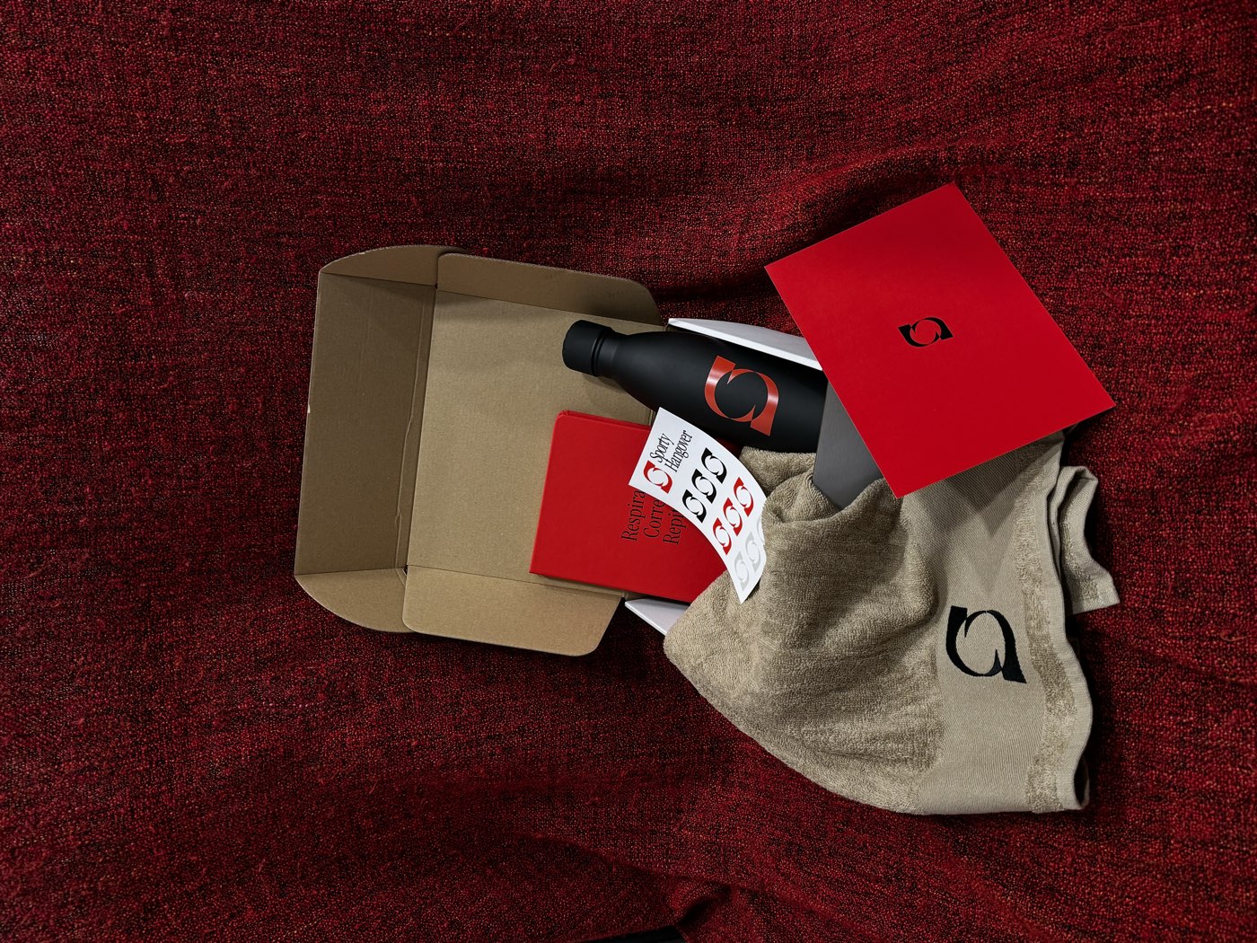 La Sporty Box abierta, con la libreta, la botella, la toalla y las pegatinas