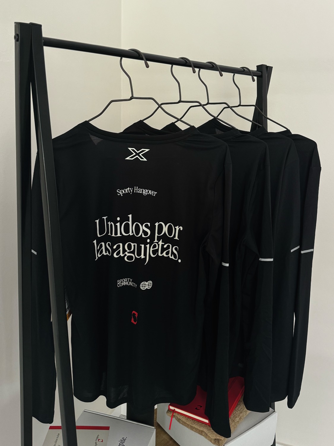La camiseta de manga larga colgada, con la frase Unidos por las agujetas